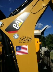 A piece of Public Works equipment bearing an American Flag and the Bow logo.